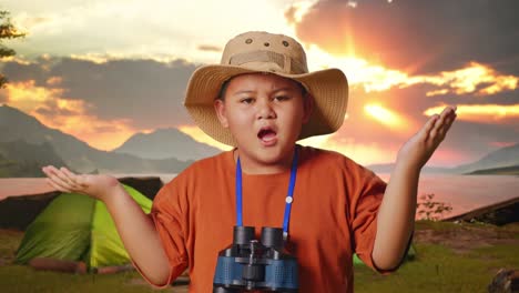 boy with binoculars at campsite during sunrise/sunset