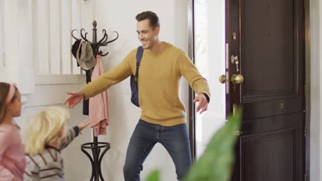 video of happy caucasian son and daughter hugging with father as he arrives home