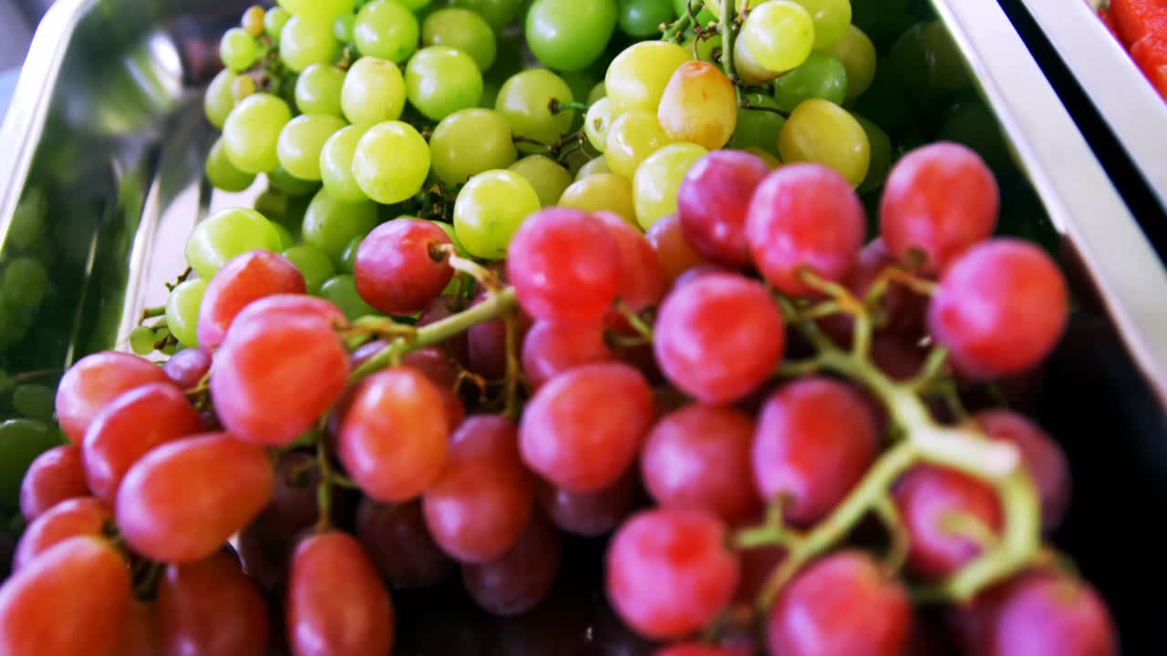 racimos verdes y rojos de uvas en bandeja