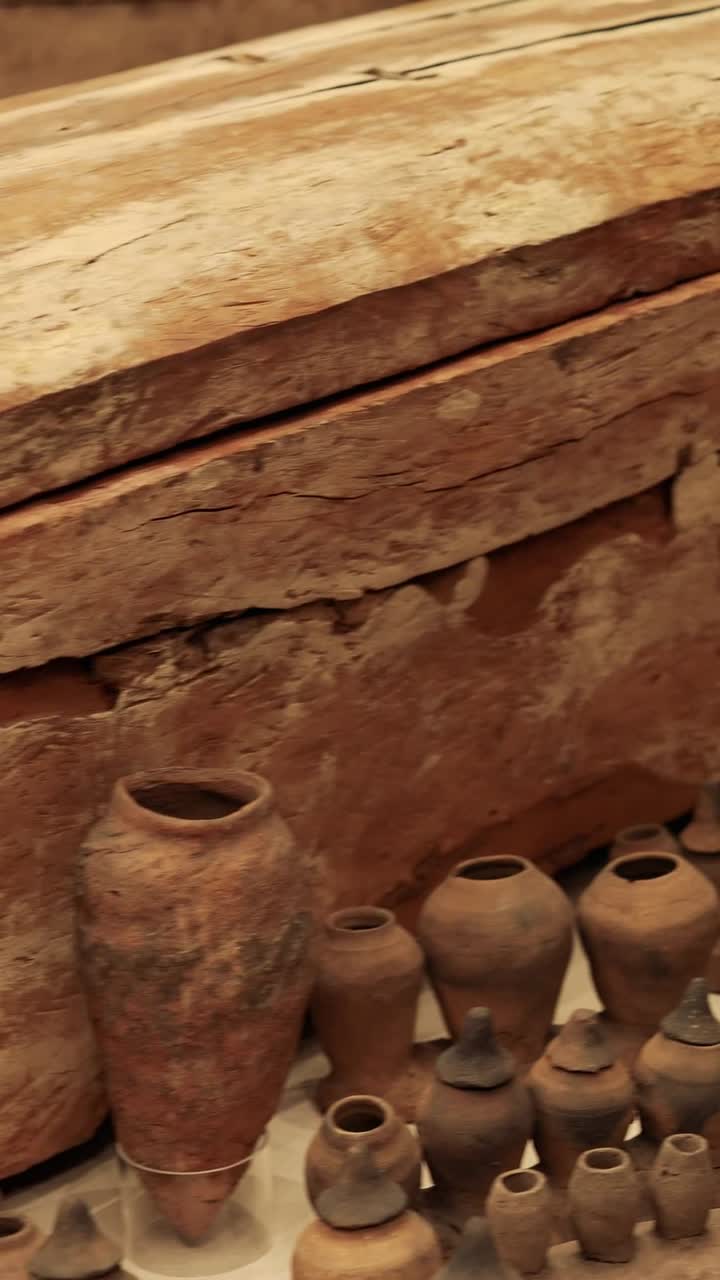 ataúd de madera rodeado de artefactos históricos de cerámica