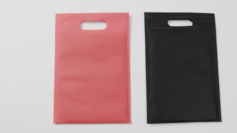 primer plano de bolsas rojas y negras sobre fondo blanco, espacio de copia, cámara lenta