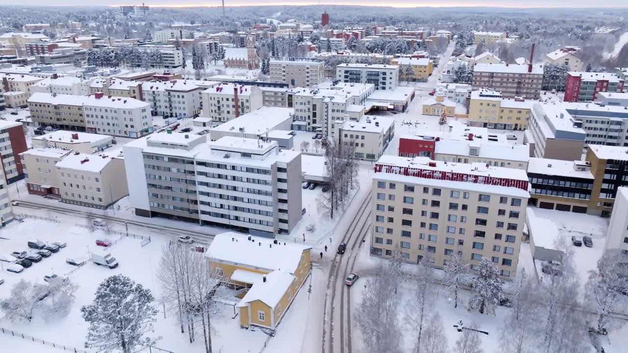 Aerial tilt shot following a car on the snowy streets Kajaani, winter in Finland