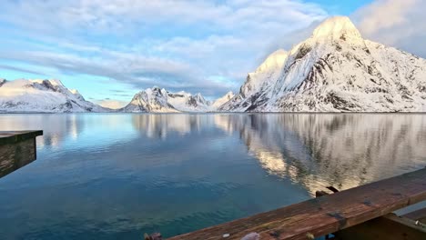 Movimiento-Reflexivo-Calmante-En-El-Mar-De-Reinefjorden,-Visto-Desde-El-Muelle-Hacia-Olenilstinden-Y-Rostad-Vinstad