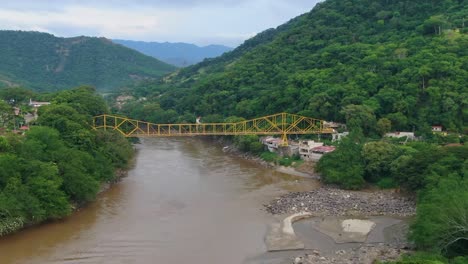 Aerial-dolly-zoom-of-yellow-suspension-bridge-in-south-america-mountains