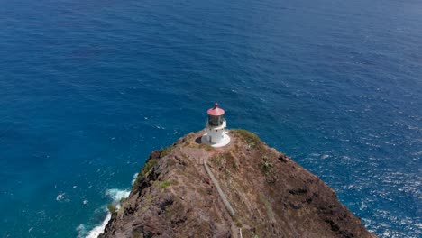 aerial flyover and tilt down reveal of makapuu lighthouse and walking trail in oahu, hawaii