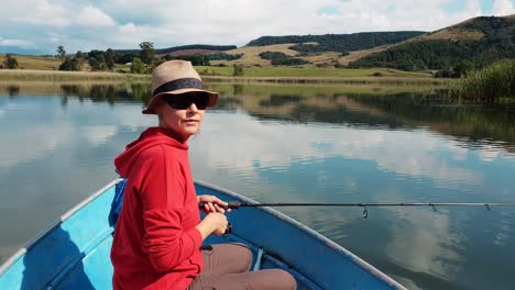 A-girl-fishing-on-a-beautiful-calm-lake-on-a-summers-day-in-Natal,-South-Africa