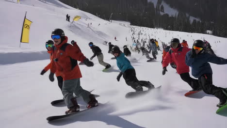 group snowboarders descending a snowy mountain slope