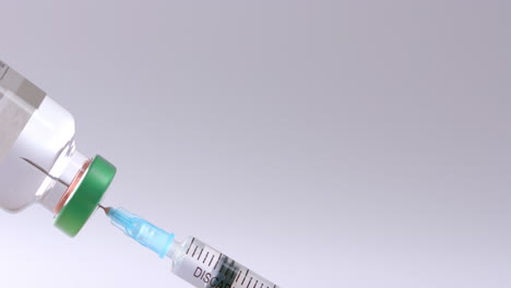 primer plano del vial de insulina y la jeringa sobre un fondo gris con espacio para copiar, cámara lenta