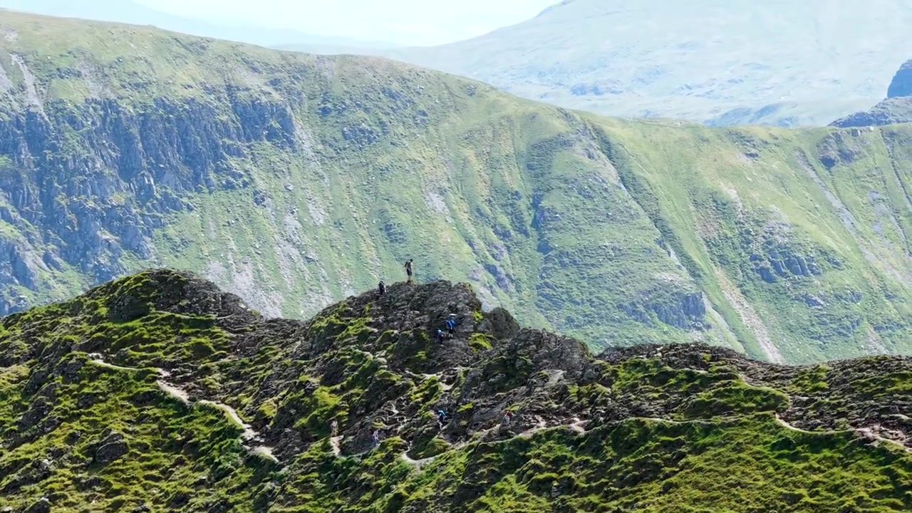 Riprese drone cinematografiche che sorvolano Helvellyn e Striding Edge in Cumbria, Inghilterra. Splendide prospettive aeree di aspre colline, Red Tarn, creste spettacolari e paesaggi pittoreschi.