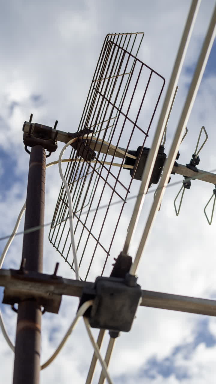 A timelapse of the sky and clouds with television aerials in the foreground