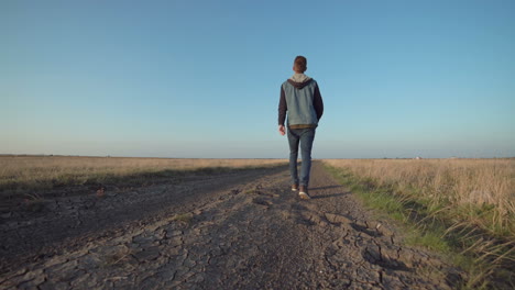 hombre caminando por un camino de campo
