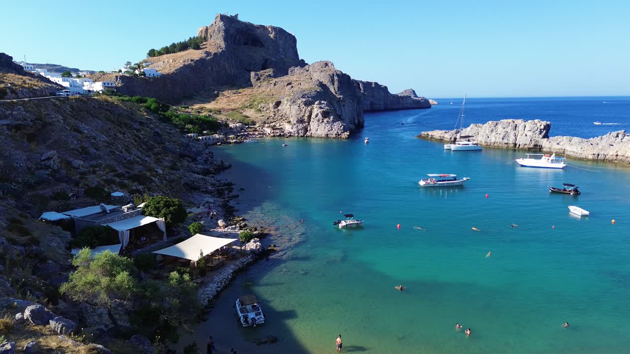 그리스 로데스 에 있는 아기오스 파블로스 해변 과 린도스 아크로폴리스, 집 들 과 지중해 는 낮 에 드론 으로 촬영 되었다