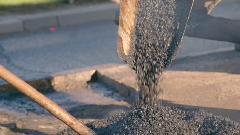 paving machine pours out the hot and steamy asphalt onto the road for repair