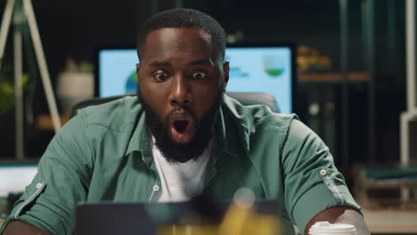 closeup shocked guy looking at laptop in office