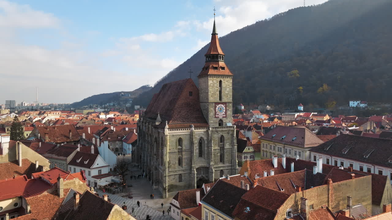 Aerial drone view of The Black Church in the city center of Brasov, Romania surrounded by mountains
