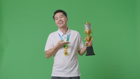 man holding a trophy and medal