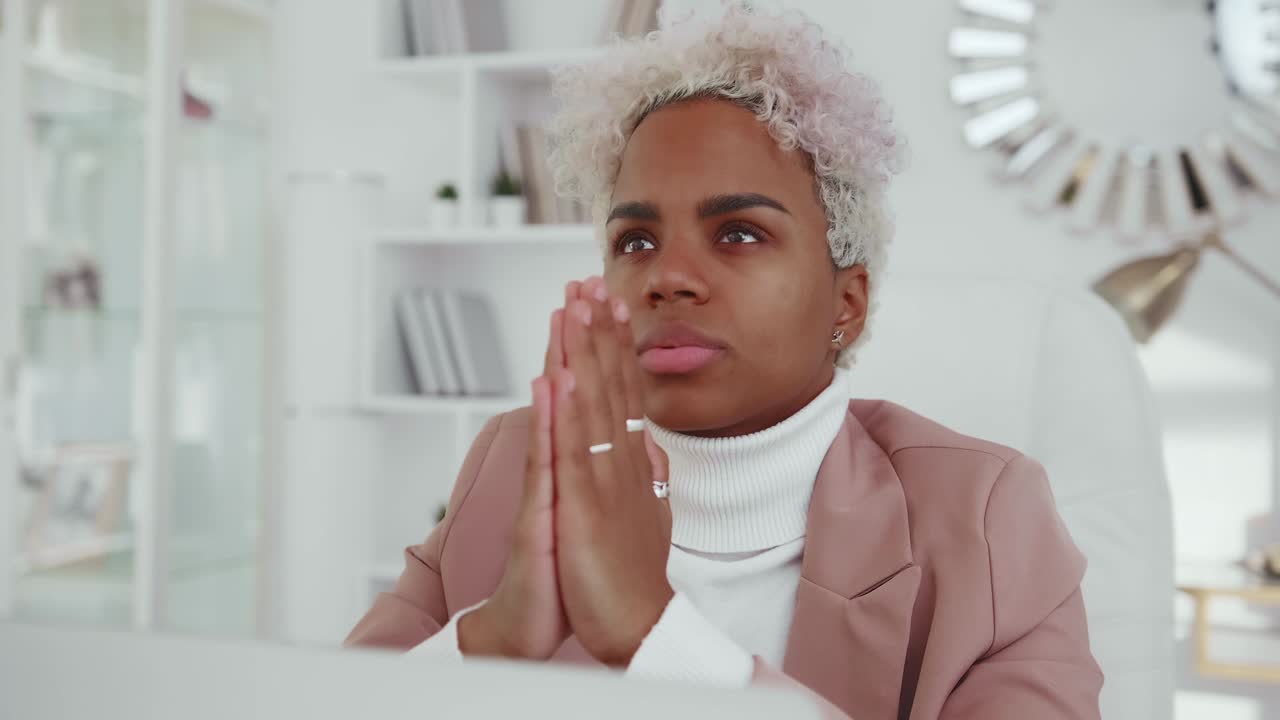 Young believer in god african american business woman praying with palms clasped