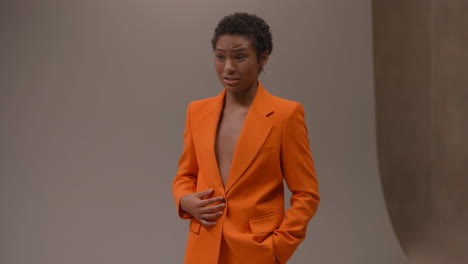 young person in orange blazer with a distressed expression