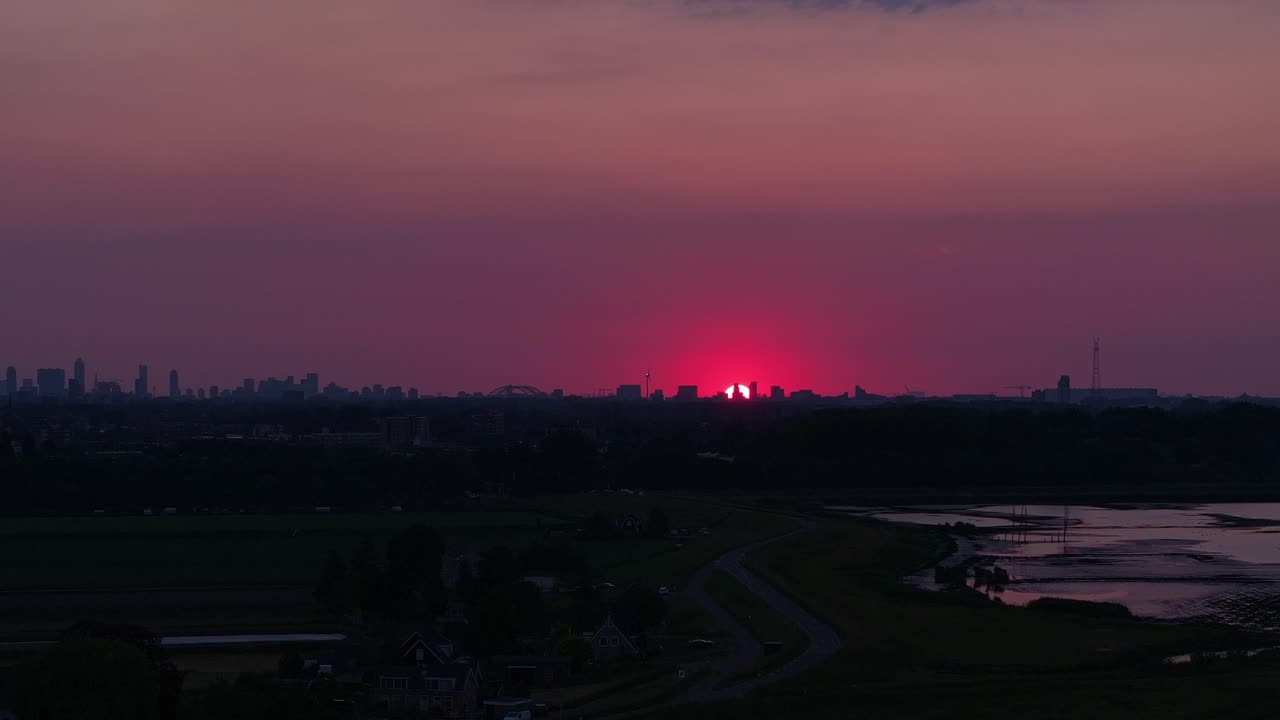 아래 로테르담 시의 극적인 은 스카이 라인과 함께 해가 지고 있습니다.
