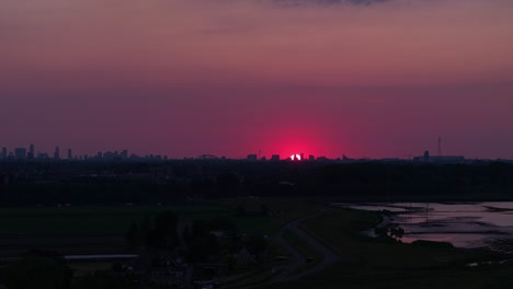Sun-setting-with-dramatic-red-skyline-over-Rotterdam-city-below