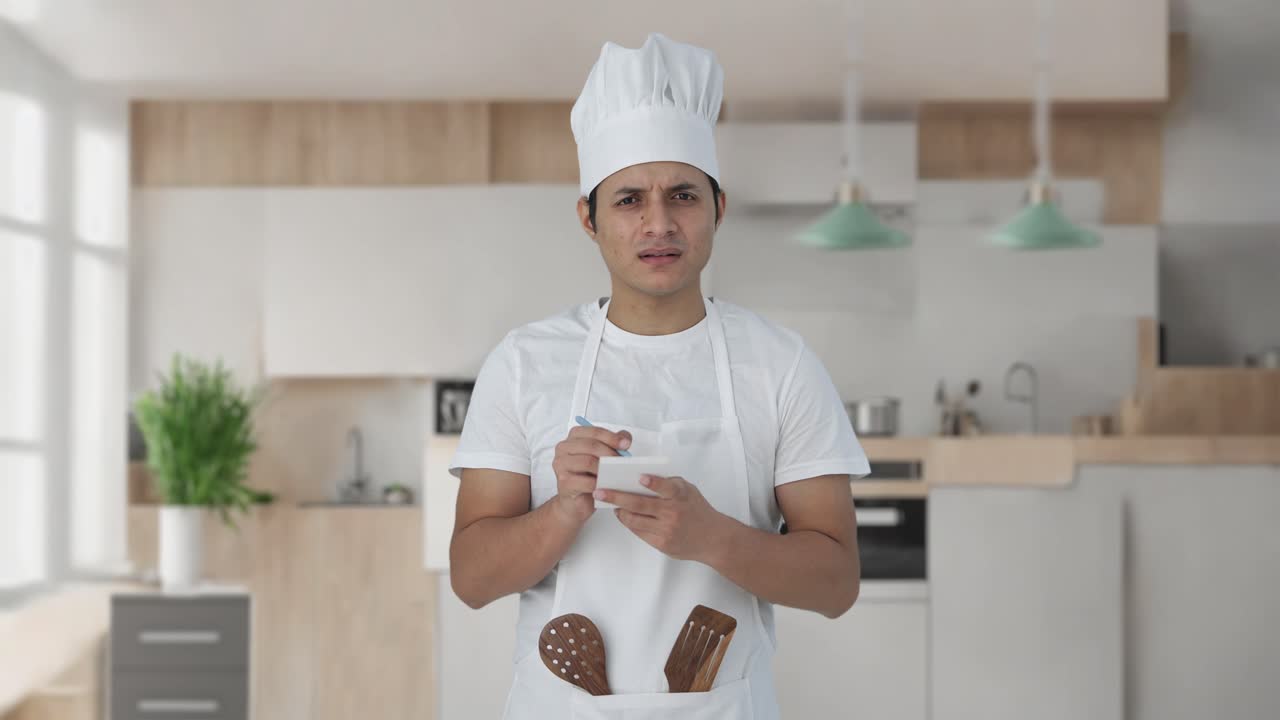 confundido chef profesional indio anotando la receta