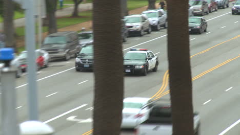 A-police-car-drives-on-a-downtown-Los-Angeles-street-by-day