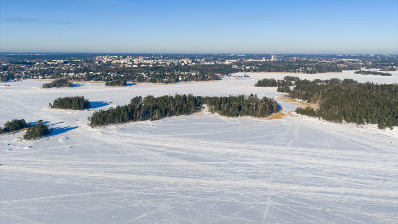 Ilmahyperlapse ihmisistä kävelemässä jäällä Suomen jäisessä saaristossa.