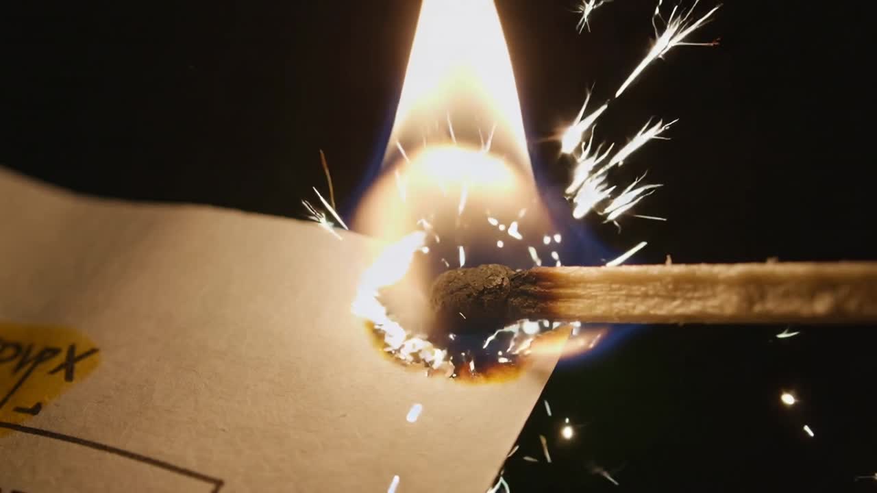 Toccando carta stampata, accendendo un fiammifero di legno che annerisce il foglio su una superficie scura, producendo scintille