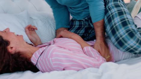 playful, comic and happy couple jump on bed