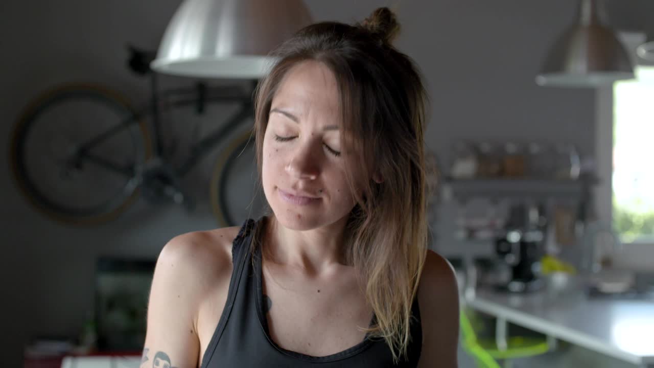 joven tatuada relajada mujer deportiva retrato en casa..sala de estar entrenamiento doméstico. video en cámara lenta 4k