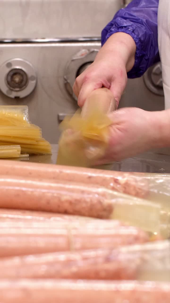 Factory worker preparing sausages