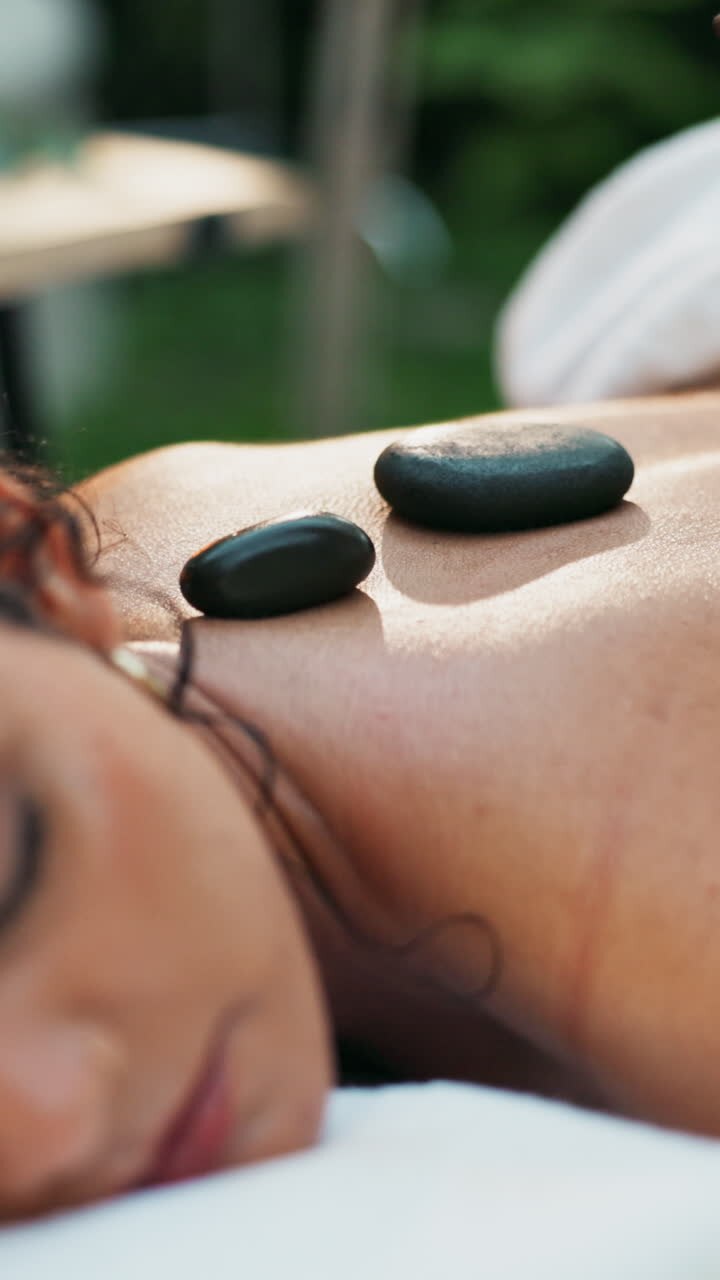 Kvinde modtager hot stone massage for afslapning og velvære