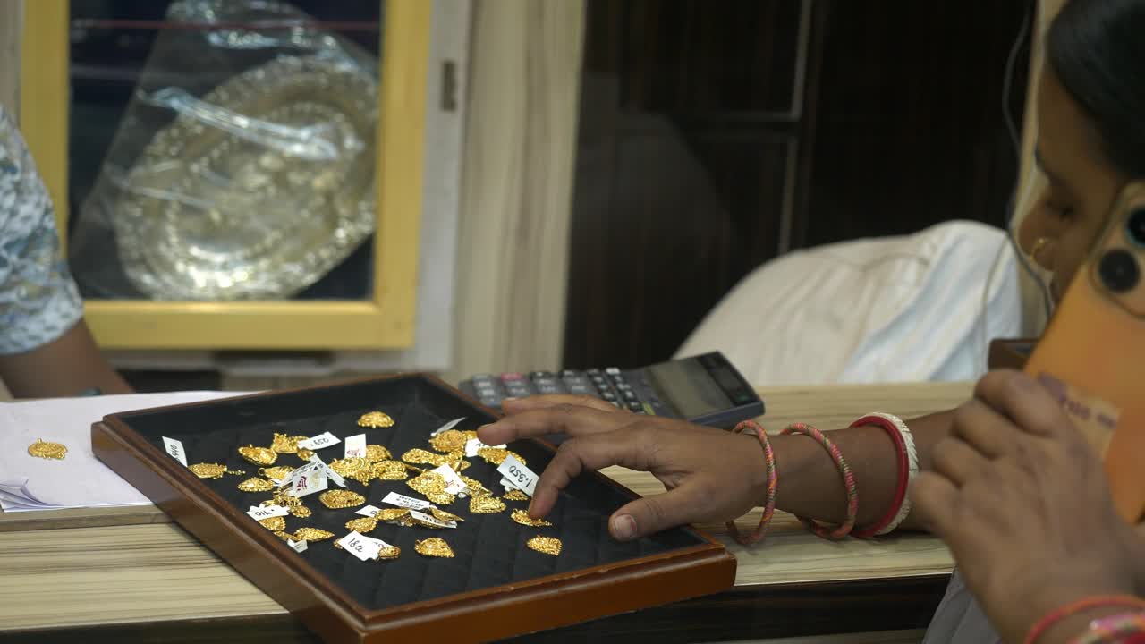 Indian woman customer shopping 22k hallmarked gold jewellery at a shop during festivals, Gold investment