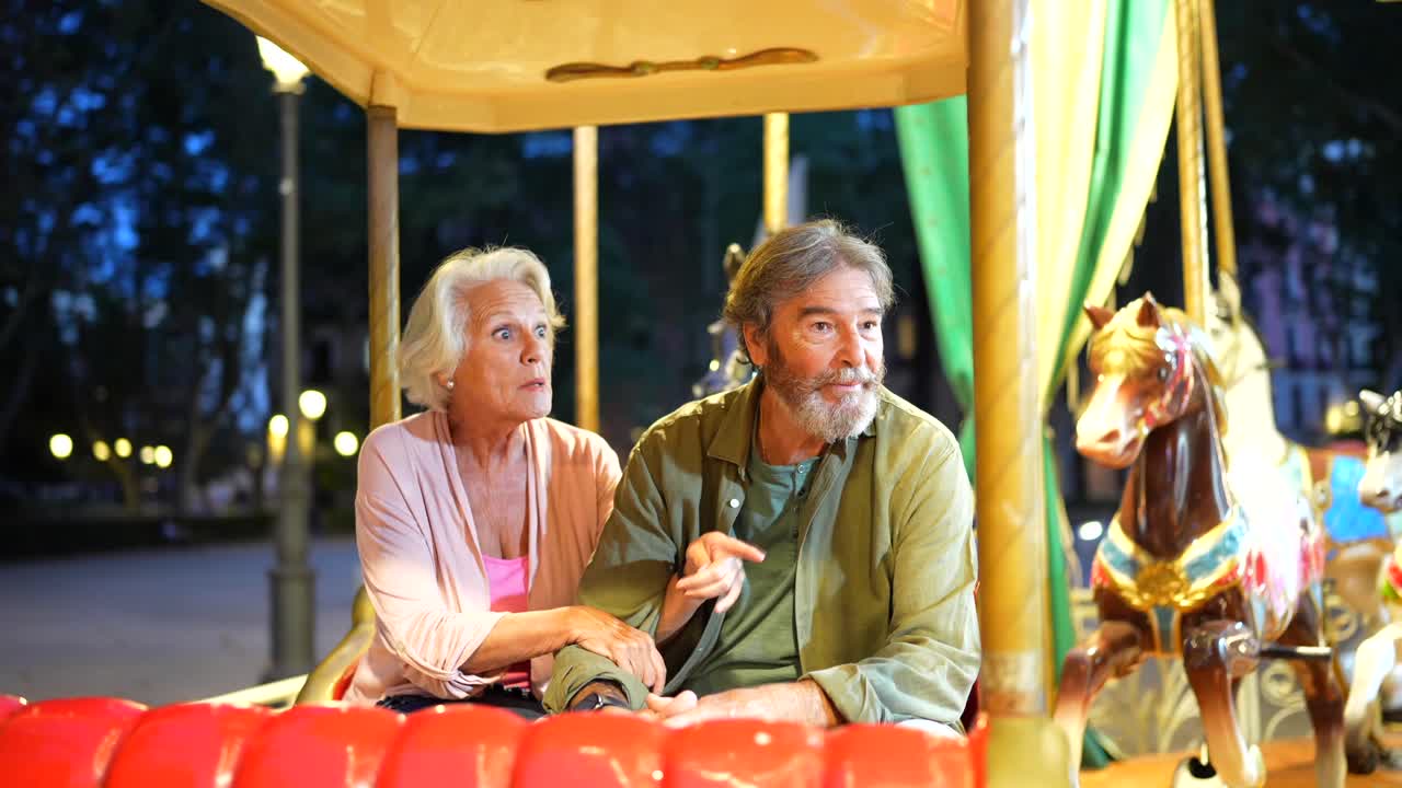 Elderly couple enjoying a carousel ride