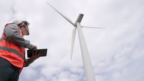 Fortschrittlicher-Ingenieur,-Der-Mit-Der-Windkraftanlage-Arbeitet,-Mit-Dem-Himmel-Als-Hintergrund.