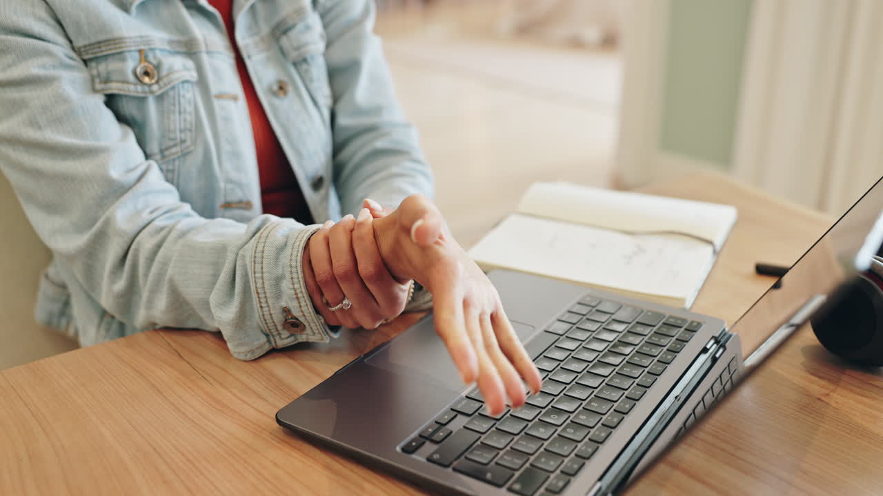 Woman experiencing wrist pain while using a laptop