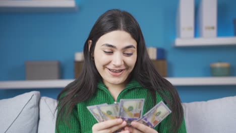 Happy-young-woman-counting-money-rejoicing-and-smiling.