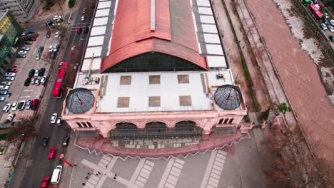 Bird's-eye-view-of-the-Mapocho-Station-Cultural-Center-with-people-walking-along-its-front-and-copper-roof,-a-heritage-site-in-the-city-of-Santiago-Chile