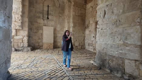 tourist taking pictures in zion gate jerusalem old city walls. slow motion.