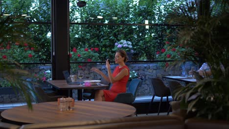 View-Of-Beautiful-Woman-Dining-Alone-Using-Phone-To-Check-Her-Teeth-Then-Using-Interdental-Brush-To-Clean-Teeth-In-Up-Market-Restaurant-Setting