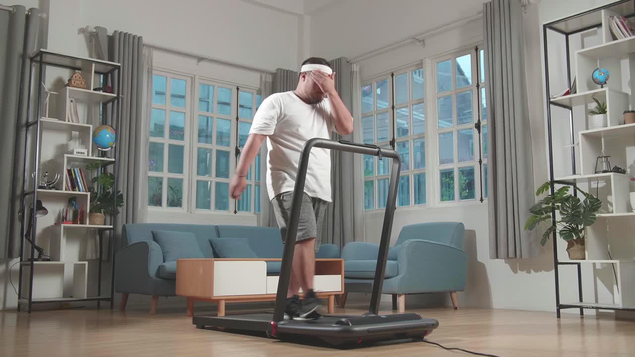 Asian Fat Man Training On Walking Treadmill At Home