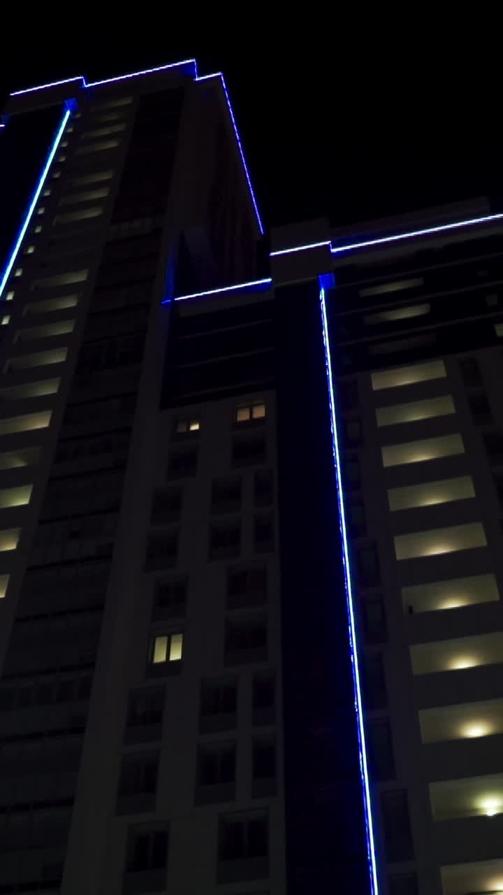 Night view of a modern high-rise building with blue LED lighting