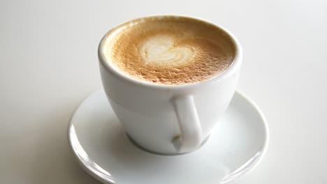 close-up of a cup of latte with heart shaped foam art