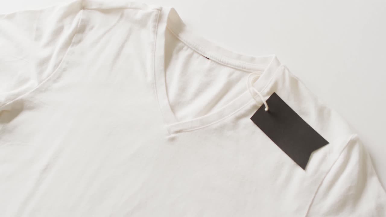 Video of close up of white t shirt with tag on white background