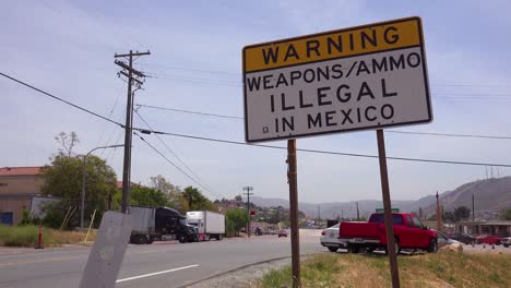 a sign announces that weapons and ammo are illegal in mexico at the us mexico border