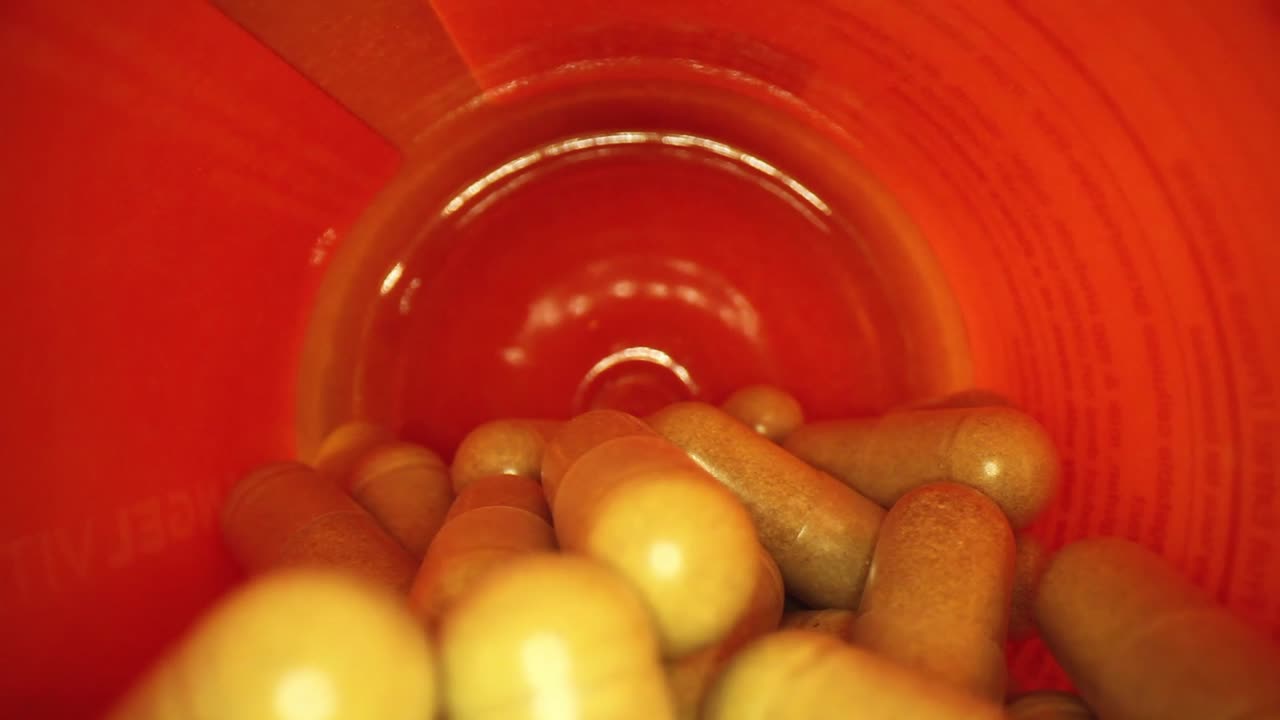 오렌지 보충제 약병의 전체 길이를 천천히 밀어 넣습니다.