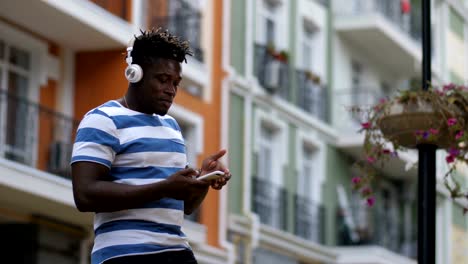 hombre con auriculares escuchando música en línea usando el teléfono