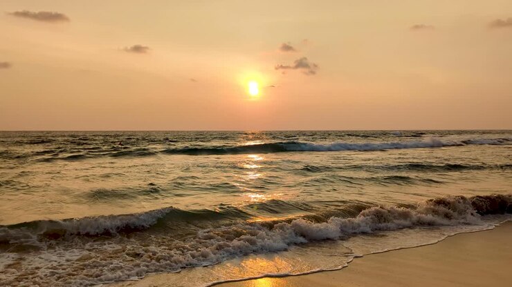 Stunning golden sunset reflecting over ocean water with waves rolling into beach, Hikkaduwa, South Coast Sri Lanka