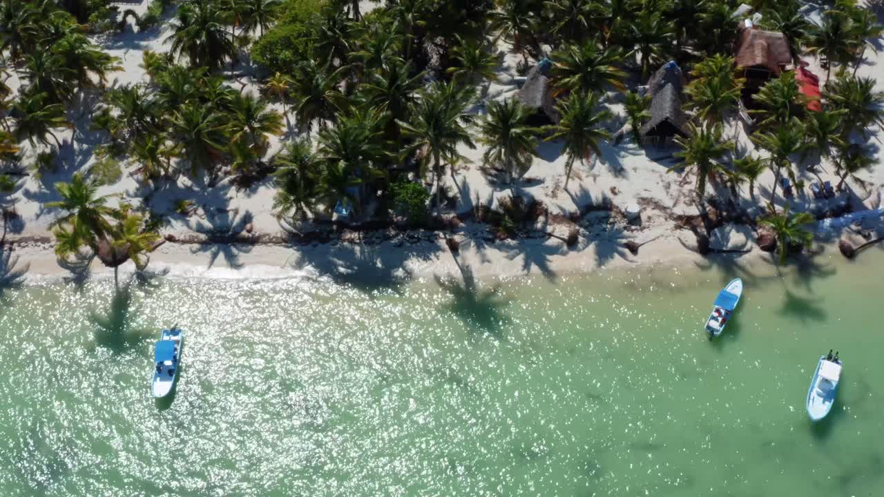vista superior de la costa de un pequeño pueblo pesquero en la reserva natural de sian ka'an cerca de tulum, méxico con pequeños barcos de pesca, muelles, palmeras y arena blanca en un día de verano