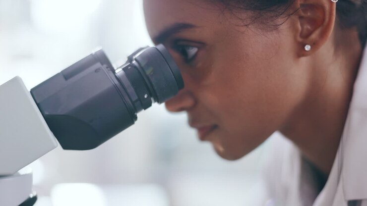 Woman, scientist and microscope in forensic